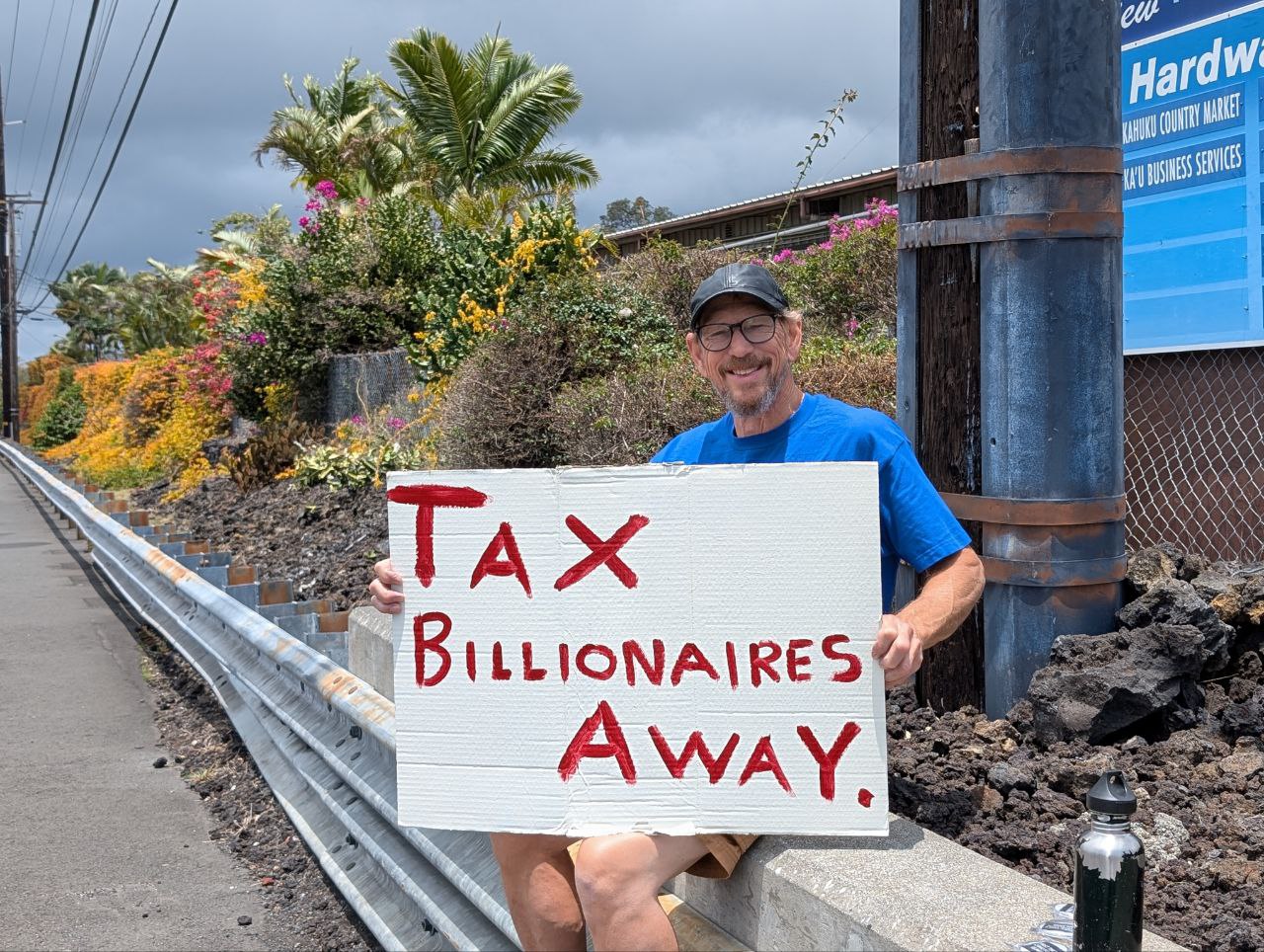 Greg holding a Tax Billionaires Away sign
